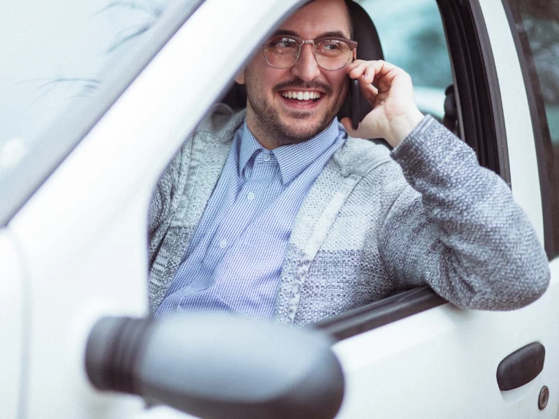 Mężczyzna rozmawiający przez telefon w samochodzie